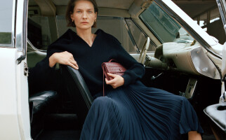 woman wearing a designer blouse and skirt with a bag