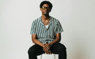 Man wearing a stripped shirt while sitting