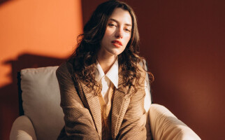 Woman wearing a brown blazer and white shirt