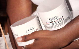Person holding various Kiehl's skincare products