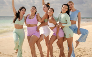 Group of women wearing pastel-coloured activewear sets on the beach