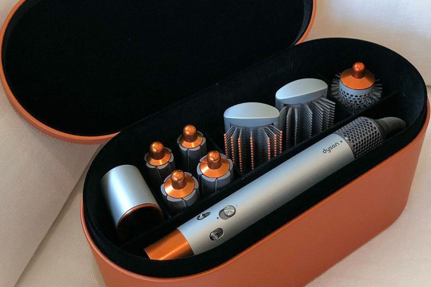 The full set Dyson Aiwrap with five attachments: smoothing, curling barrels, blowdry brush and the soft and firm smoothing brushes in the orange/copper shade with display case.